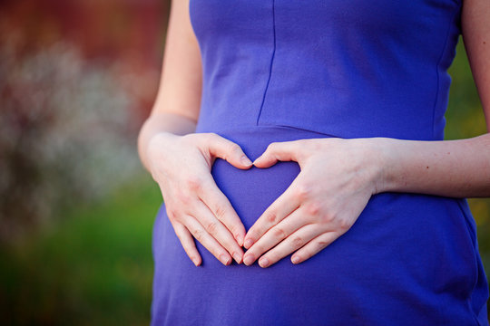 Close Up Of Young Woman Hands On Tummy Creating Heart Shape Wear