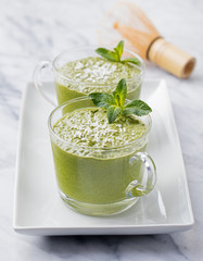 Matcha green tea chia seed pudding, dessert with fresh mint and coconut on a white stone background Healthy breakfast 
