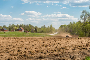 Tractor plowing fields between Finspång and Ljusfallshammar during spring in Sweden.