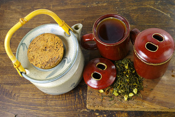 Japan's teapot and cups with green tea on wooden plank