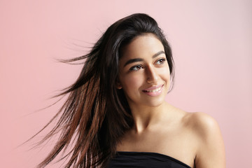 Fototapeta premium blowing hair of maroccan girl on a pink background