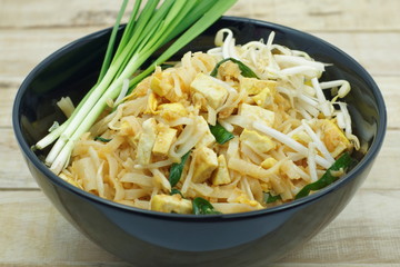 Thai fried noodle in black bolw with bean sprouts and Garlic chi