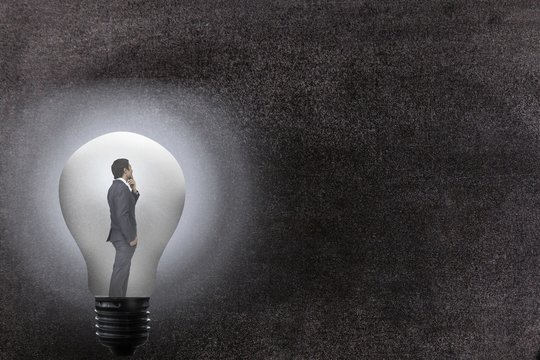 Composite image of a businessman inside a light bulb 