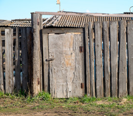 Fototapeta na wymiar Old wooden fence and a door in the countryside