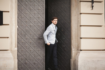 Stylish businessman walking outdoors and looking away