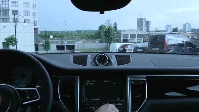 man uses the display in the car in rainy weather.