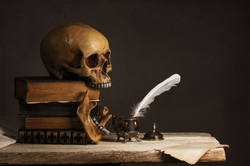 human Skull on old Books with empty Page, Feather and Inkpot