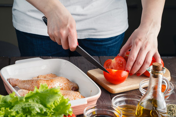 Woman cut tomato for cooking chicken