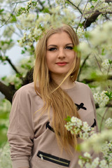 Naklejka premium Beautiful,cute,nice,blonde,happy,smiling,joyful,young,attractive,healthy girl,model in the blossoming,white garden,outdoors.Spring.Portrait.Fresh.Natural.Luxurious.Cherry.Day.Landscape.Springtime,nice
