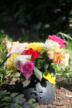 Friedhofsvase mit bunten Rosen auf einem Grab - Textfreiraum