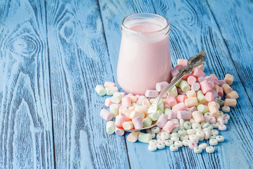 Pastel colored candy in a pile on a blue surface