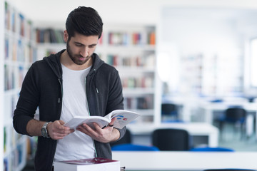 portrait of student while reading book  in school library