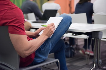 male student taking notes in classroom