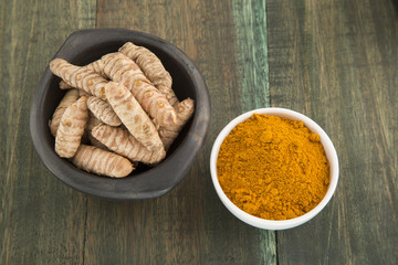 turmeric powder in white bowl on wooden background