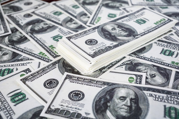 Big pile of money. Pile of one hundred dollar bills. Fake money. Money background. Business concept. Shallow depth of field. Selective focus.