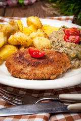 Delicious meal of minced meat cutlet, potatoes and fried cabbage