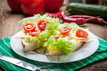 Delicious sandwich with tomatoes, cheese and lettuce.