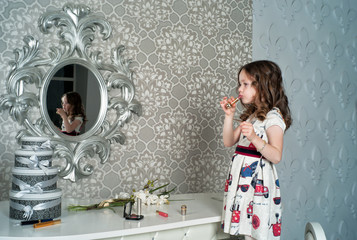 Young fashionista with lipstick at the mirror