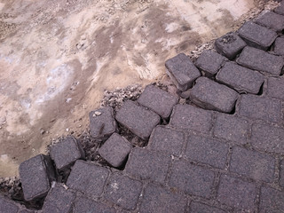 brick pavement dissolving diagonally into sand