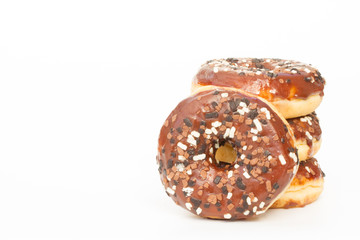 A stack of donuts with chocolate icing and sprinkles on an isolated, white background.