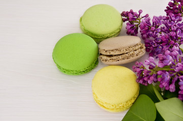 French macaroons with twigs of lilac. Close-up.
