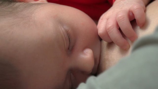 Beautiful one month old baby sucking milk - breastfeeding
