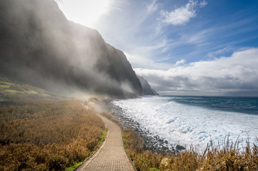 Madeira island wild bay with mountains in fog