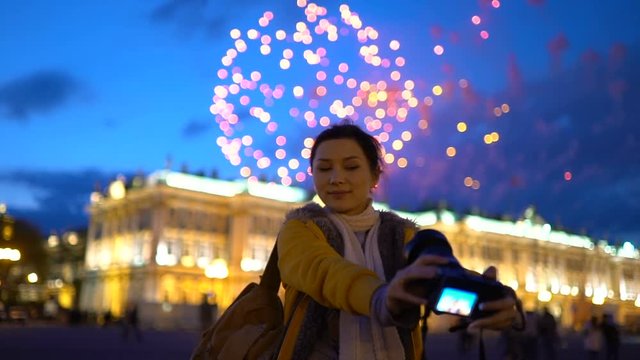 Pretty girl using camera to take selfie at the fireworks 