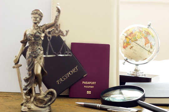 Law concept, statue, magnifying glass, passport and world map. Travel