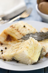 boiled fish on white plate and boiled potato in bowl