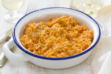 rice with seafood in dish with glass of white wine