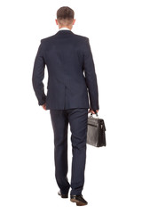 Businessman with briefcase walking away on white