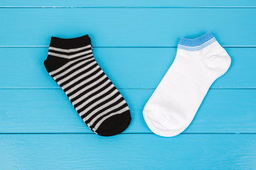 Pair of socks laying on a blue background.