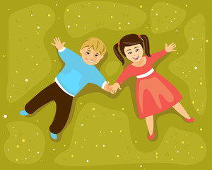 Boy and girl lying on a meadow and holding hands