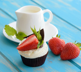 Tasty cake with pieces of fruit and strawberry on a table
