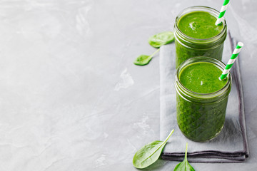 Spinach smoothie Healthy drink in glass jar on grey stone background