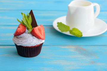 Tasty cake with pieces of fruit and strawberry on a table