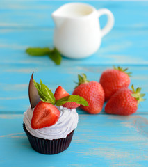 Tasty cake with pieces of fruit and strawberry on a table