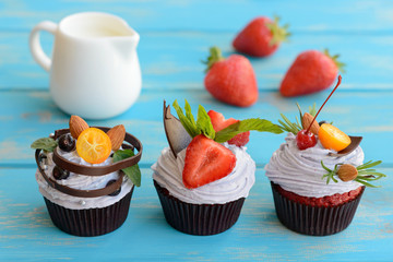 Tasty cake with pieces of fruit and strawberry on a table