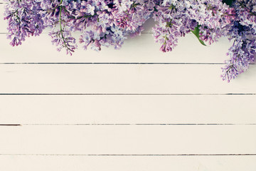 Lilac flowers on vintage wooden background. Top view, copy space
