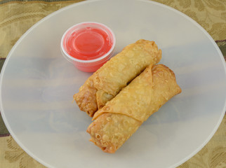 Egg Rolls and sweet and sour sauce on dinner plate