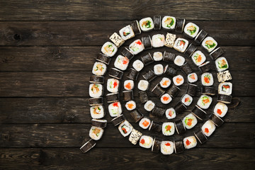 Set of sushi maki and rolls at black rustic wood.