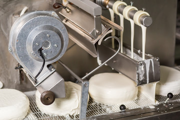 Conveyor with white cakes. Machine pours liquid onto cakes. Fresh and delicious. Simple yet delicious confectionery.