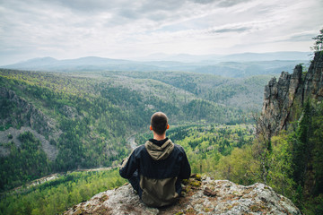 Man sitting on the top of the mountain in meditation session in Lotus Posture, padmasana,...