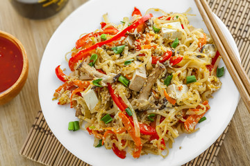Traditional oriental food made of rice noodles, vegetables, shiitake and tofu. Asian meal. Top view, close-up..