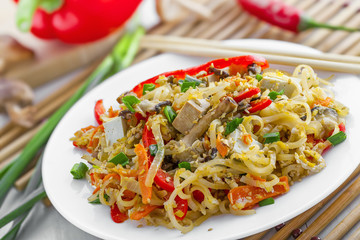Oriental food made of rice noodles, tofu, vegetables and shiitake mushrooms. Delicious Oriental cuisine meal.