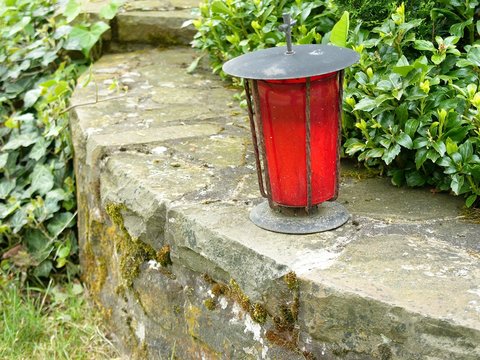 Rote Grableuchte auf alter Mauer auf dem Friedhof in Wettenberg Krofdorf-Gleiberg bei Gie&szlig;en in Hessen