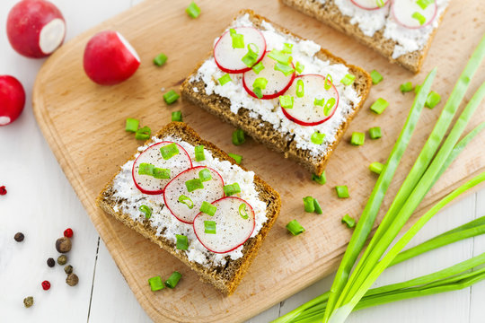 Open ray sandwiches with soft cream cheese and radish. Tasty summer snacks.
