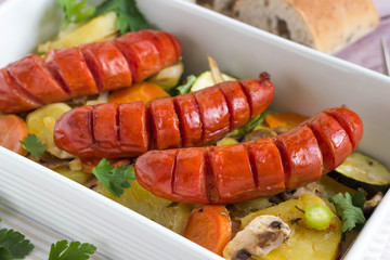 Sausages and grilled vegetables in baking dish