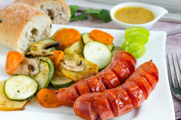 Grilled sausages and vegetables with sauce